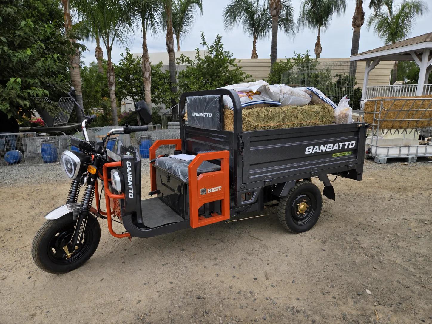 Ganbatto cargo tricycle carrying hay and feed at a work site